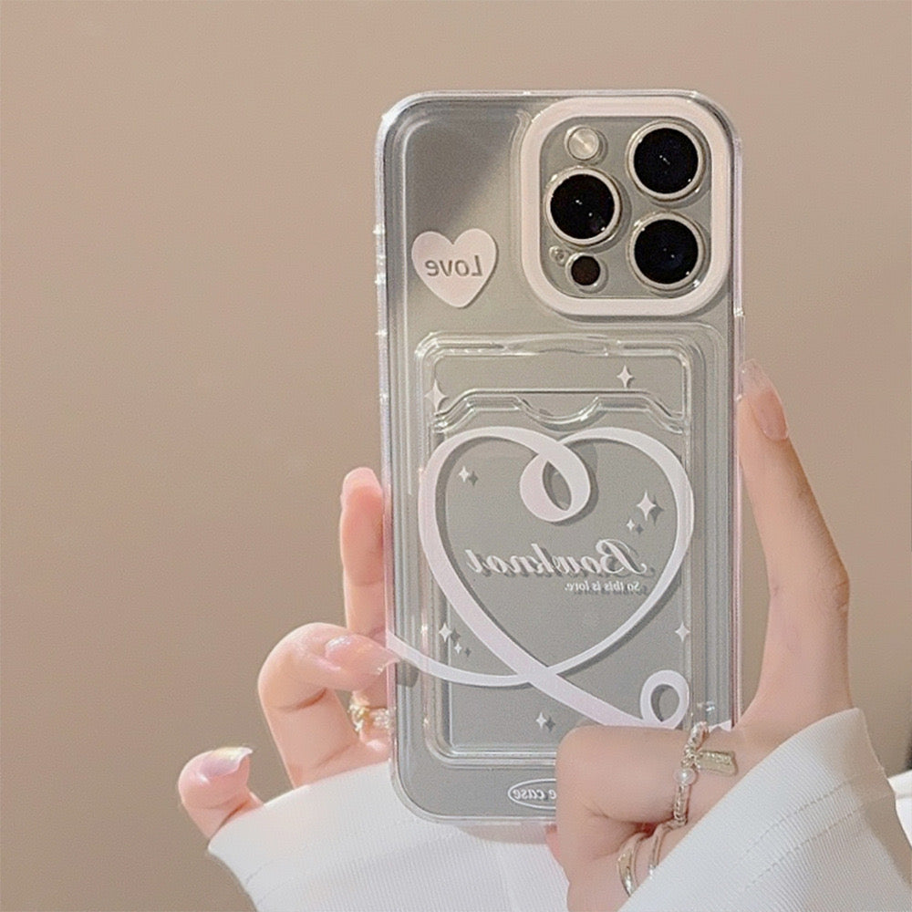 Clear iPhone case with heart and โbonjourโ design, featuring a small โLoveโ sticker, providing stylish and protective coverage.