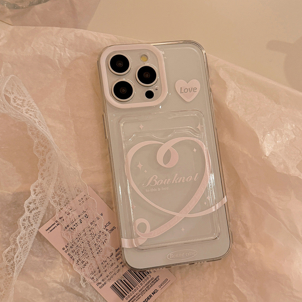 Clear iPhone case with heart and ‘bonjour’ design, featuring a small ‘Love’ sticker, providing stylish and protective coverage.