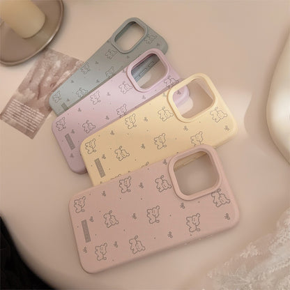 Pastel iPhone cases in pink and beige with a playful pattern of ribbons and dogs, offering stylish and protective coverage.